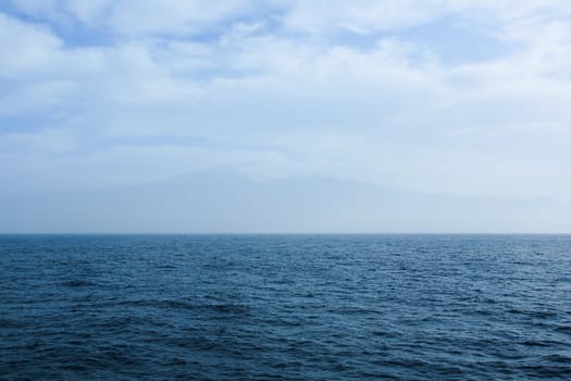 Distant mountains (island) at atlantic ocean