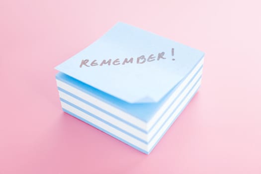 Pile of sticky notes with text over a pink table