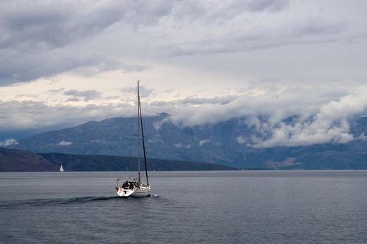 A boat is sailing in a  sea. Stormy clouds on the back