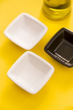 Empty vases and olive oil bottle over a yellow background