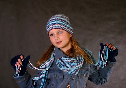 Portrait of the girl in a winter cap, gloves and a scarf