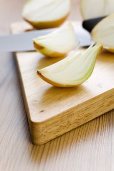 Onion halves with knife on the wooden table