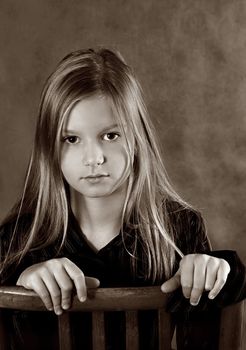 Portrait of the young girl with hands in studio. b/w+sepia
