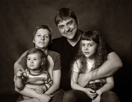 Family portrait on a dark background in studio