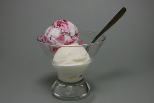 Ice cream with berry jam on grey background.