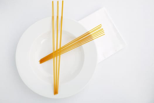 Abstract uncooked red (tomato) pasta on the white plate