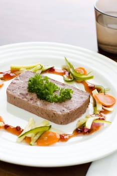 Game pate with the vegetables on the white plate