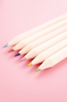 Pile of wooden pencils over a light red background