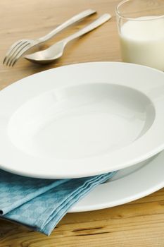 Empty dinner plate with glass of milk