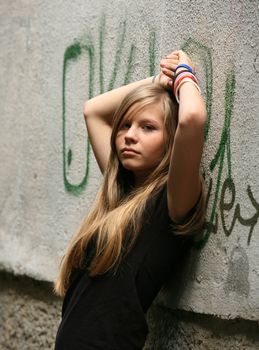 The girl - teenager on a background of a wall