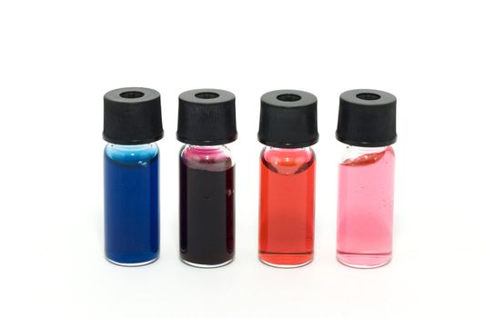 Vials with colored liquid on white background