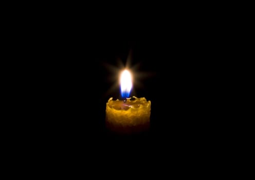 Candle in darkness isolated