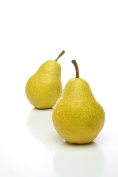 A pair of yellow pears with drops, one on front and one  backwards over a white background. Look for more fruits and vegetables at my gallery