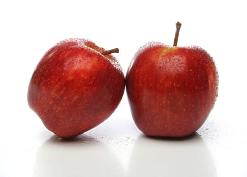 A pair of delicious red apples with drops, side by side over a white background. Look at my gallery for more fruits and vegetables