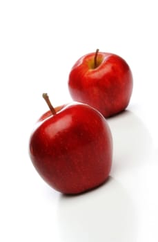 A pair of delicious red apples, one on front and one  backwards whith a soft lighting over a white background. Look at my gallery for more fruits and vegetables