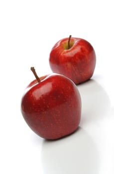 A pair of delicious red apples, one on front and one  backwards over a white background. Look at my gallery for more fruits and vegetables