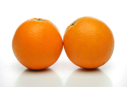 A pair of juicy oranges, side by side over a white background. Look at my gallery for more fruits and vegetables