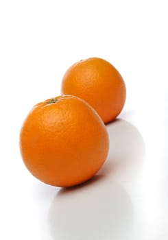 A pair of juicy oranges, one on front and one  backwards over a white background. Look at my gallery for more fruits and vegetables