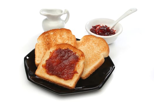 Three toast on a black plate with red jam behind. White background. Deliciuos food for breakfast.  Look at my gallery for more meals