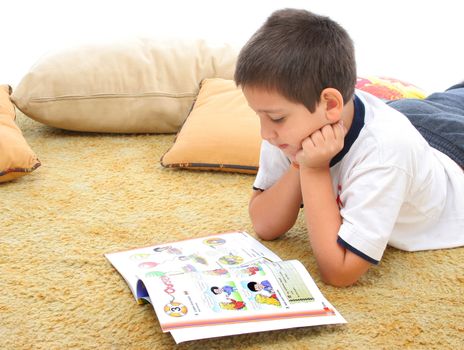 Boy in a room reading a book over a carpet. He looks interested and concentrated. Visit my gallery for more images of children
