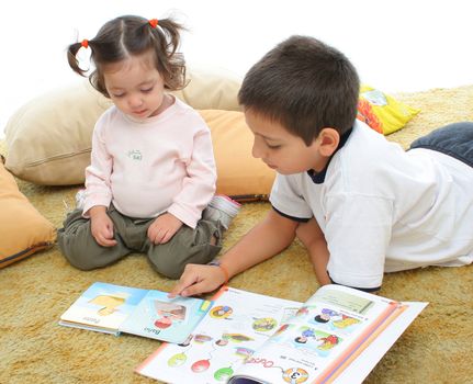 Brother and sister reading books over a carpet. They look interested and concentrated. Visit my gallery for more images of children
