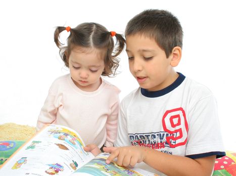 Brother and sister reading a book over a carpet. They look interested and concentrated. Visit my gallery for more images of children
