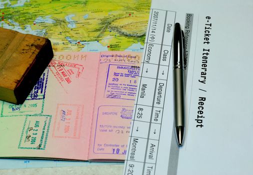 e-ticket iterenary passport and rubber stamp lain in a world map - conceptual for travel, business trip and holidays.