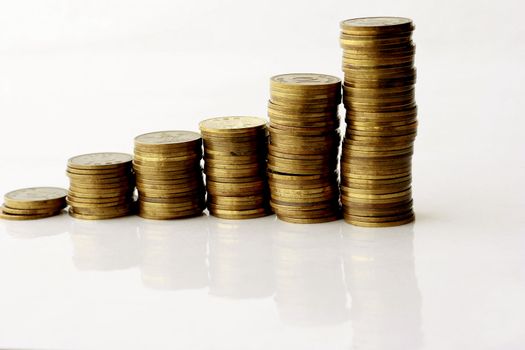 Business Concept - Coins stack up getting highier in a white background