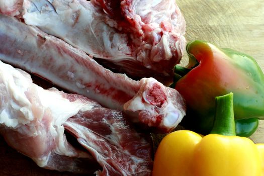 Slices of fresh raw meat with red & yellow pepper in a chopping board