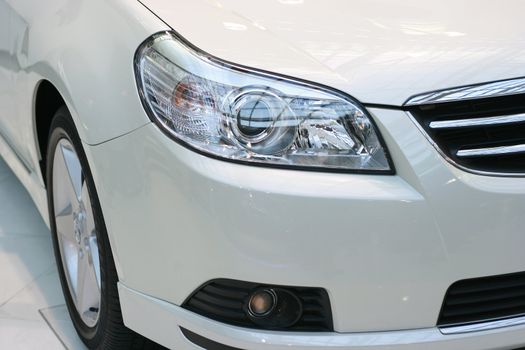 Front view detail of a car headlight and bumper