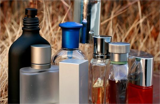 assorted Fragrances bottles in an outdoor dried grass background