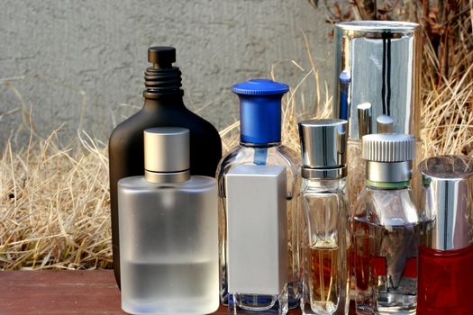 Assorted Fragrances bottles in an outdoor shot with dried grass background