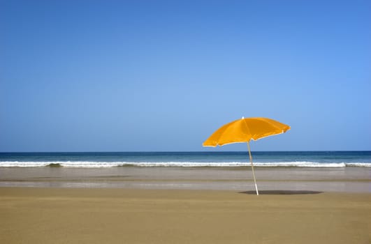 Beautiful tranquil beach with a orange hat on the sand