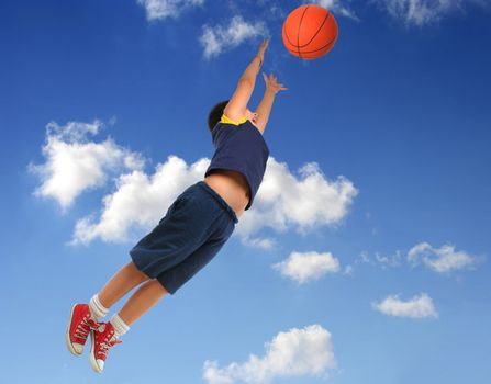 Boy playing basketball isolated. Flying and jumping with blue sky. From my sport series.