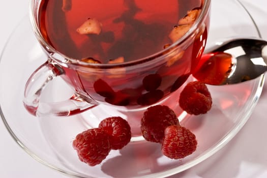 Cup of tea with raspberry syrup and some raspberries