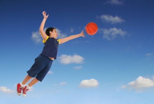 Boy playing basketball jumping and flying. Blue sky. From my sport series.