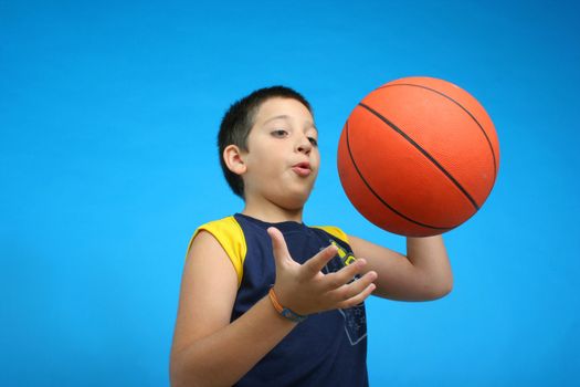Boy playing basketball isolated. blue background. From my sport series.