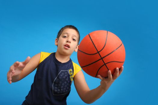 Boy playing basketball isolated. Blue background. From my sport series.