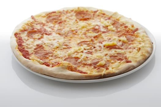 Pizza (filled with ham and pin apple) on the plate over white background