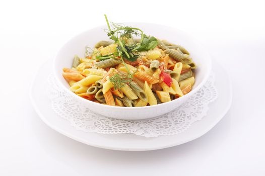 Italian colorful penne pasta in white bowl over a white background