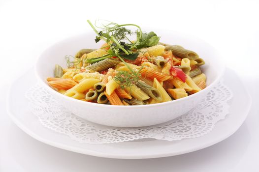 Italian colorful penne pasta in white bowl over a white background