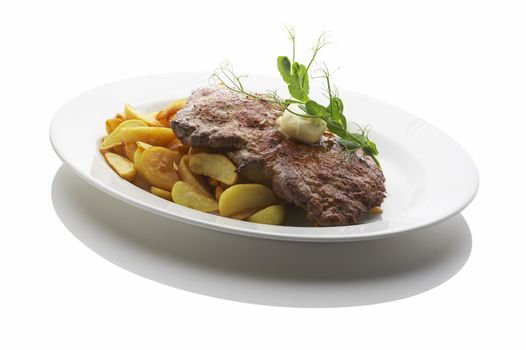 Deep fried potatoes and a large steak over white background