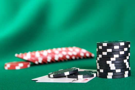 Stack of chips and two aces on green linen background