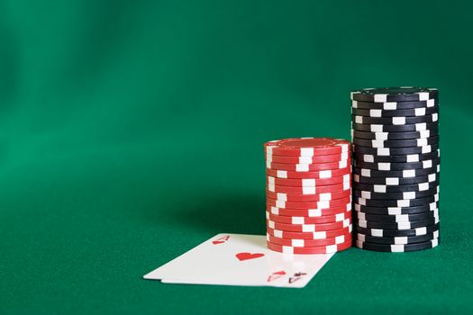 Stack of chips and two aces on green linen background