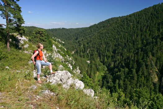 Female trekker is looking at the valley