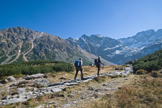 Couple trekking in Tatra Mountains during late autumn, Poland