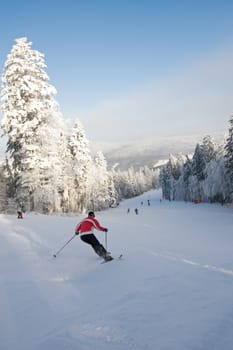 Mountain ski rider in red on ski slope