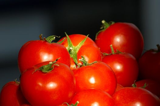 group pf fresh ripe tomatoes on dark background, selective focus