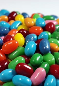 Multiple colored jelly beans on a light background.