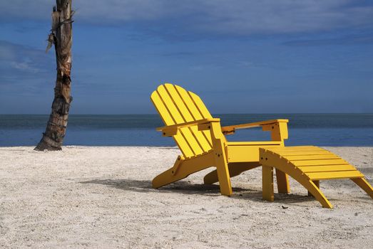 A inviting scene of a comfortable yellow beach chair on a tropical beach